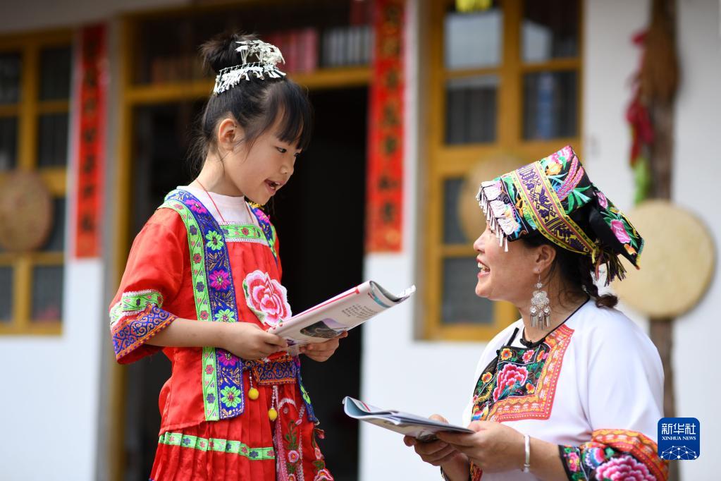 7月19日，湖南省邵阳市城步苗族自治县长安营镇民族文化传播服务中心，一名小朋友在向“六月六”山歌节市级传承人陈岩花（右）学习唱山歌。新华社发（严钦龙摄）